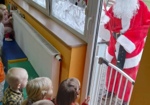 Dzieci wyglądają przez okno w poszukiwaniu Mikołaja