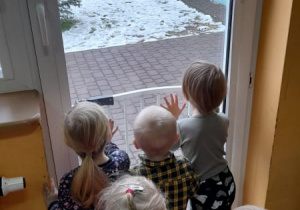 Dzieci wyglądają przez okno w poszukiwaniu Mikołaja